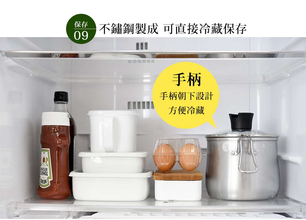 不鏽鋼製成的料理鍋，鍋身呈現銀色金屬光澤，帶有可折疊的銀色把手和透明鍋蓋。鍋旁有番茄醬瓶、白色儲物盒和雞蛋。