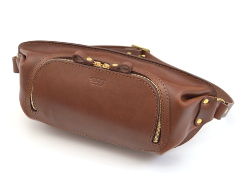 職人手作皮革拉鍊旅行斜背包，採用光滑棕色皮革製作，設有黃銅色拉鍊和金屬扣環，設計簡潔實用。