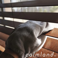 一隻戴著灰色超細纖維清潔手套的手，正在擦拭木質百葉窗的葉片。