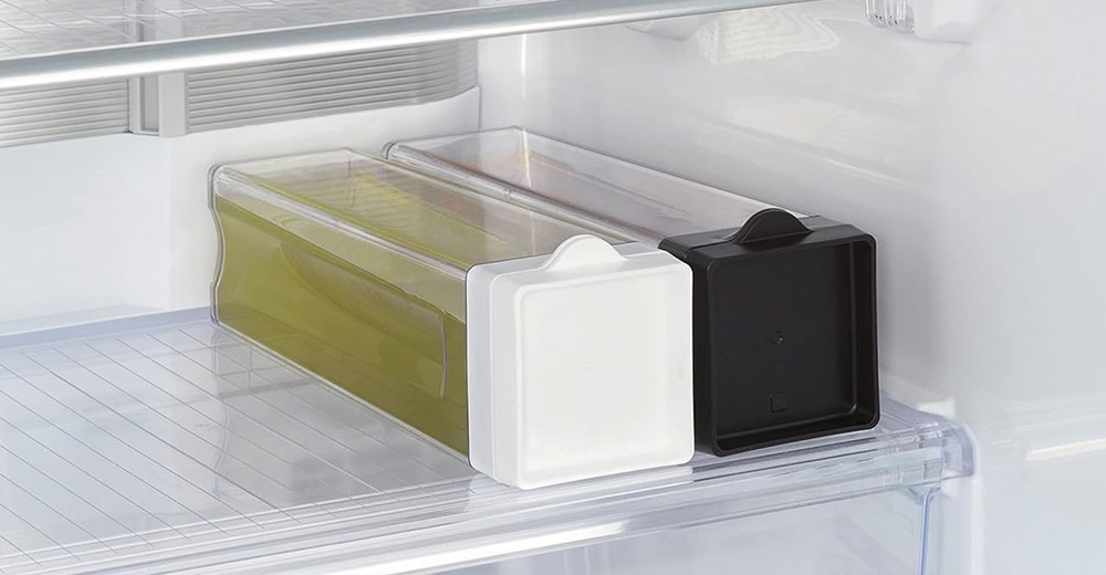 冰箱內兩個直橫放防漏冰箱冷水壺，一個裝有綠色液體，搭配白色瓶蓋，另一個為黑色瓶蓋。