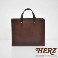 職人手作皮革直式托特包，深棕色，簡約設計，有兩個皮革提把，包身由皮革製成，並以金屬鉚釘固定邊角。