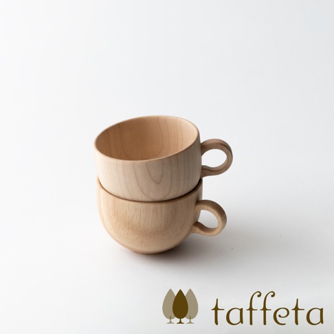 兩個疊放的淺色楓木茶杯，帶有圓形把手，呈現自然的木紋。
