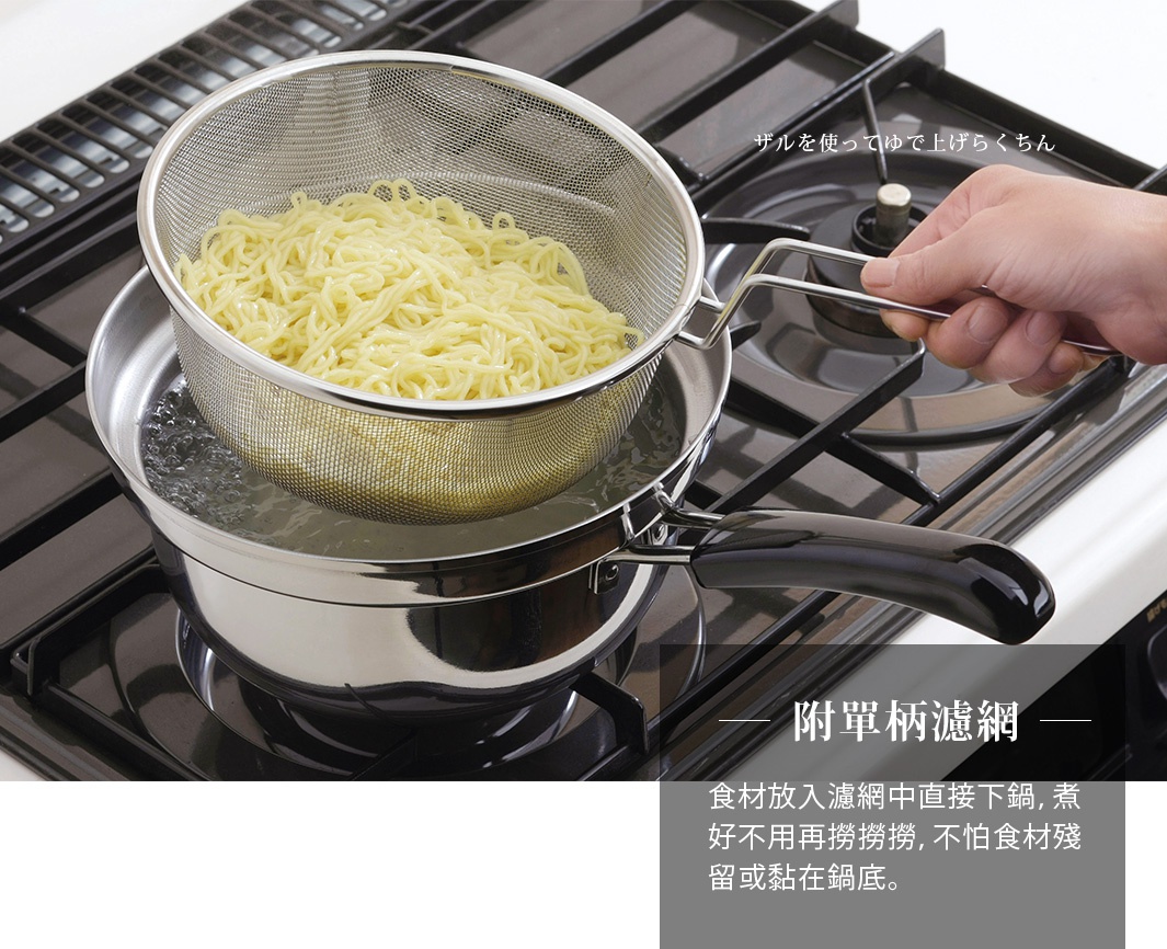金屬製防溢汆燙鍋，內含濾網，鍋底有滾水，濾網內有黃色麵條，一只手正握著濾網的銀色金屬把手，鍋身為不鏽鋼材質，把手為黑色。
