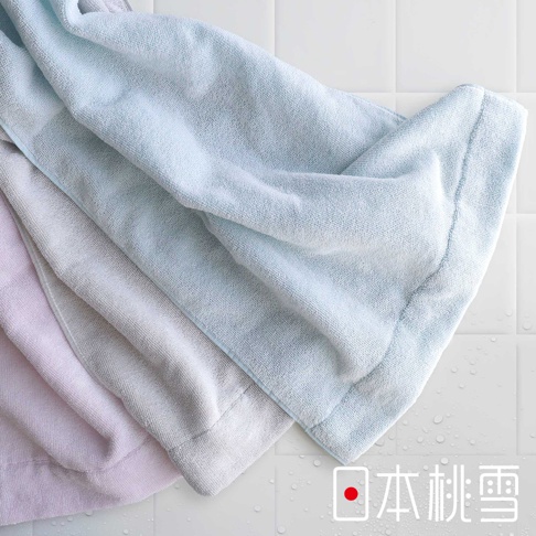 三條疊放的迷你浴巾，顏色分別為淡粉色、淺灰色和淺藍色。浴巾材質呈現柔軟蓬鬆的毛圈織法，邊緣有明顯的包邊處理。