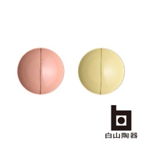 兩只陶瓷平茶碗，一只為粉紅色，另一只為淺黃色，碗面皆有垂直的細長線條裝飾。