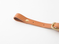 職人手作寬 3 公分的淺棕色皮革背包胸前扣帶，帶有黃銅铆釘和黃銅扣環，以及可調節的孔洞。