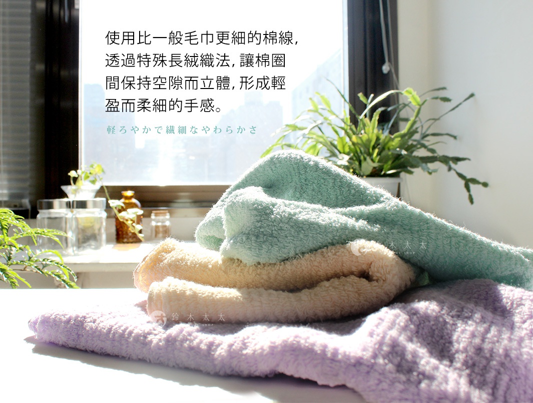 今治細絨浴巾，由細緻棉線製成，觸感蓬鬆柔軟。圖片展示了三條不同顏色的浴巾，分別為淺綠色、米黃色和淡紫色，皆為棉質材質。