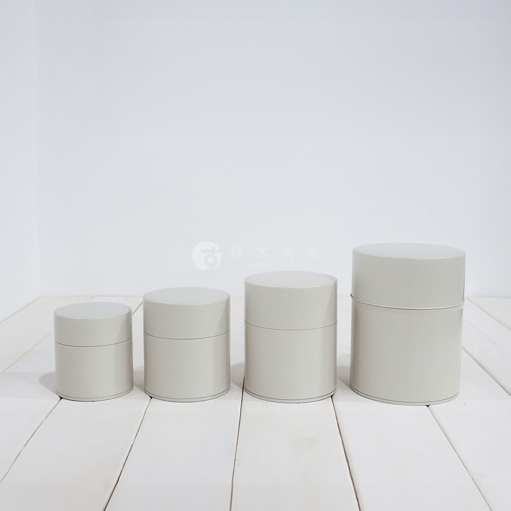 四個不同尺寸的淺灰色圓柱形錫製茶葉罐，罐身簡約無裝飾，帶有密封蓋。