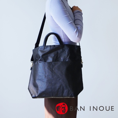BAN INOUE 釉面亞麻布三用托特包，黑色，模特斜背展示。