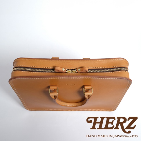 職人手作皮革手提商務公事包，採用棕褐色皮革，配有金色拉鍊及金屬扣環。