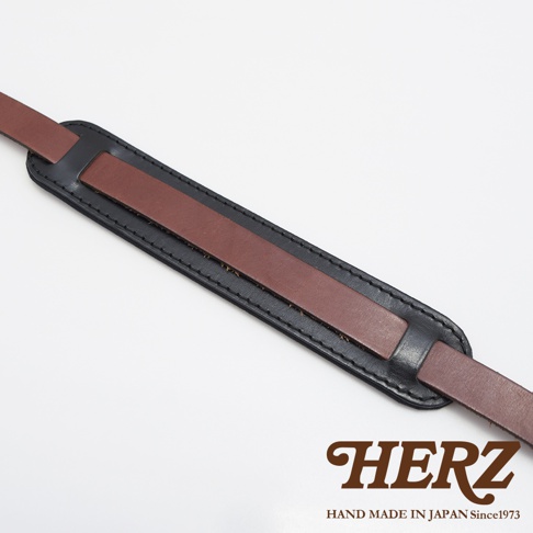 職人手作皮革Big肩墊，黑色外層皮革搭配中間棕色皮革，整體採雙層皮革縫製，並有皮革揹帶延伸。