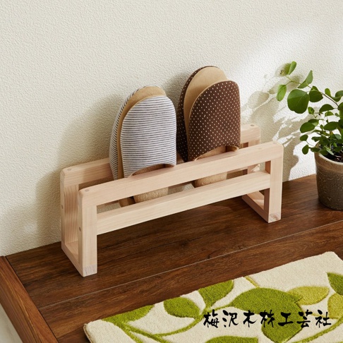 簡約木製拖鞋架，淺木色，可收納兩雙拖鞋，一雙為灰白條紋，另一雙為棕底白點圖案。