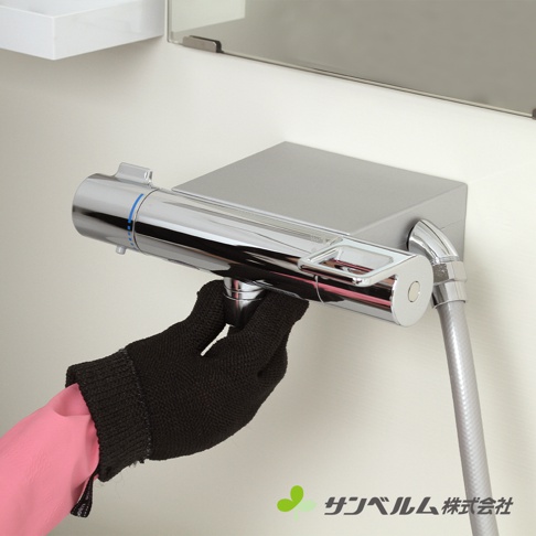 一隻穿著黑色網狀清潔手套的手，正操作著一個銀色金屬蓮蓬頭龍頭，手套內側露出一部分粉紅色橡膠手套。