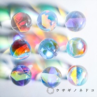 九顆圓形透明玻璃稜鏡球，內部呈現彩虹般的光影折射，有紅色、橘色、黃色、藍色、紫色等色彩，球體表面光滑，背景為模糊的彩色光暈。