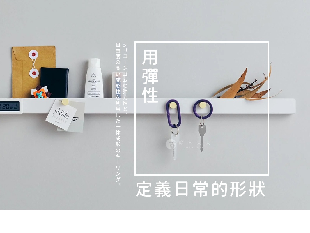 這是一張展示 SiNG QQ 彈性鑰匙圈的廣告圖片，牆上的白色長條架上陳列著辦公小物與保養品，中央的方形白框內展示了橢圓形與正圓形的紫色彈性矽膠鑰匙圈，並掛著金屬鑰匙，圖片左側標註著利用矽膠高彈性與一體成型的特色，整體氛圍簡約質感，下方文字強調產品定義日常形狀的意象。