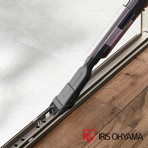 充電式輕巧多功能吸塵器 SCD-160P 的灰色刷頭配件，正在清潔木質地板上的滑軌縫隙。吸塵器本體為銀白色與黑色，配有透明集塵筒。