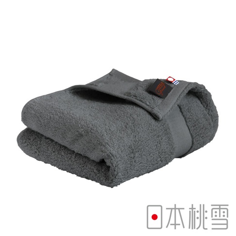 一條深灰色今治匹馬棉毛巾，質地柔軟，帶有品牌標籤，疊放在白色背景上。