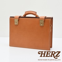 職人手作皮革兩用機師箱，主體為淺棕色皮革，配有黃銅色鎖扣和提把，車線為白色。