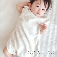 一位穿著白色水玉點點無撚紗質透氣寶寶防踢被心的嬰兒。