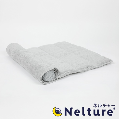 Amaze plus Nelture 捲捲快眠今治毛巾枕-二代，灰色毛巾枕頭捲起，露出內部網狀結構，左側為捲起部分，右側為展開部分，枕頭上印有品牌標誌和日文文字。