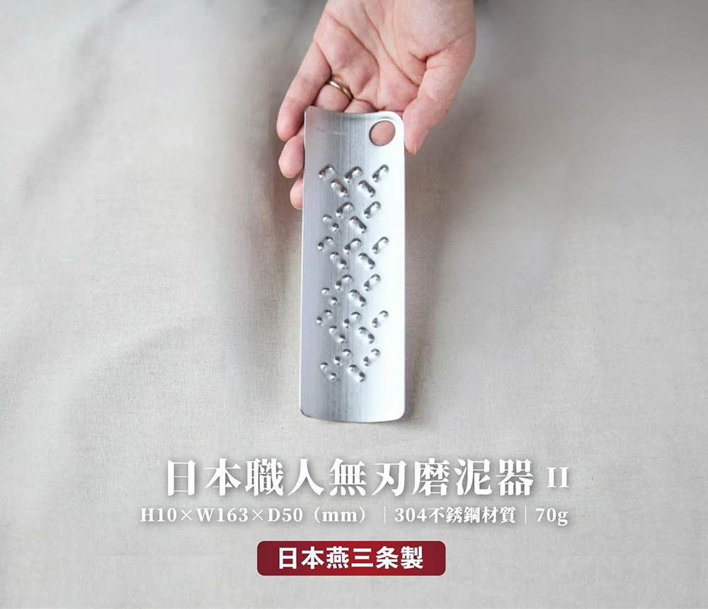 這是一張產品宣傳圖，照片中一隻手正拿著 TOMITA 品牌的日本燕三条製無刀刃磨泥器，磨泥器呈長條狀，由 304 不鏽鋼製成，表面有規律的突起磨泥結構，上方有一個懸掛孔，圖片底部標註了商品尺寸 H10 乘以 W163 乘以 D50 毫米以及重量 70 克。