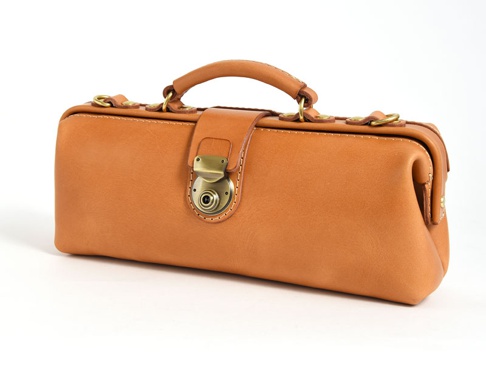 職人手作皮革橫長形單肩包，採用棕褐色皮革，配有復古黃銅色金屬鎖扣、提把和D型環，包身線條硬挺，縫線清晰。