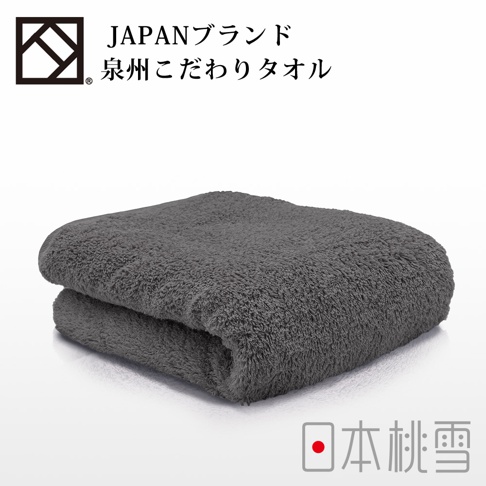 一件摺疊的深灰色加厚毛巾，質地柔軟蓬鬆，毛圈清晰可見。上方有日文品牌標誌。
