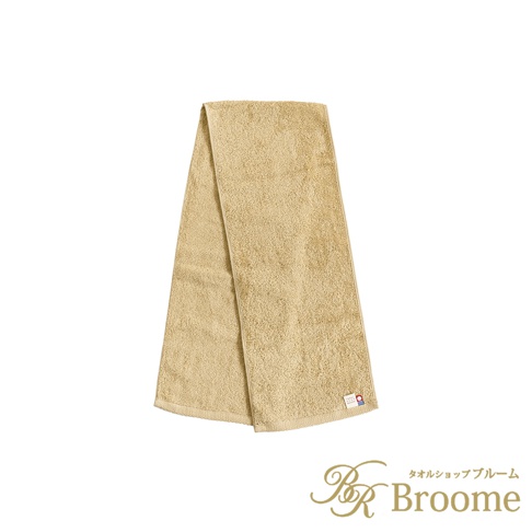 一條淺褐色（或稱卡其色）的純棉掛脖毛巾，質地柔軟，帶有明顯的毛圈，一角有品牌標籤。