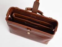 職人手作皮革橫式收納袋中袋，採用溫潤的咖啡棕色皮革製成，設有雙層內袋，外部有金屬釦環與提把，整體呈現經典復古風格。