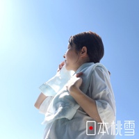 一位女性用淺藍色毛巾擦拭臉頰，毛巾掛在頸部，背景為晴朗的藍天。