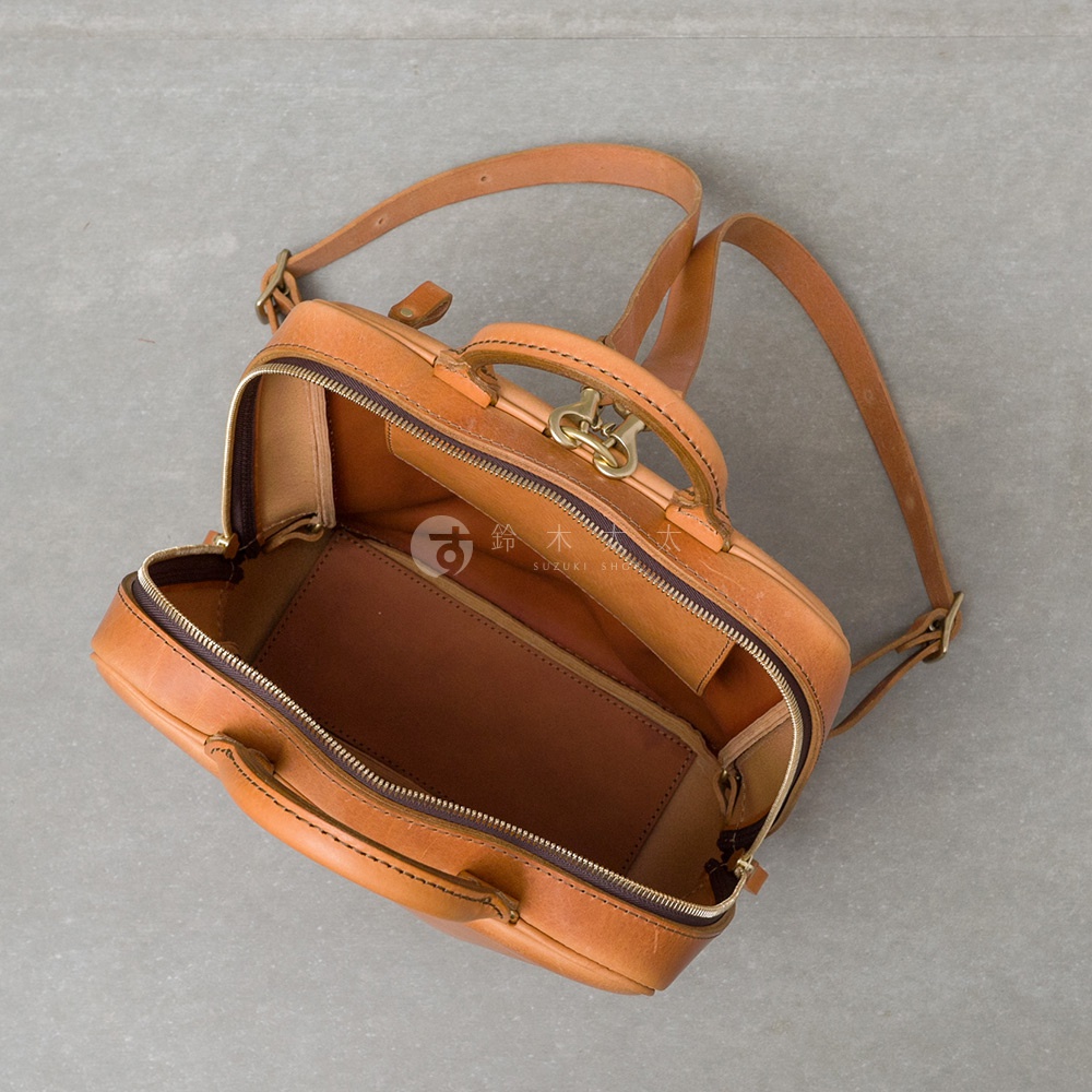 職人手作皮革Organ商務後背包，淺棕色皮革，頂部提把與可調節肩帶，包身拉鍊開口，內部有隔層設計。