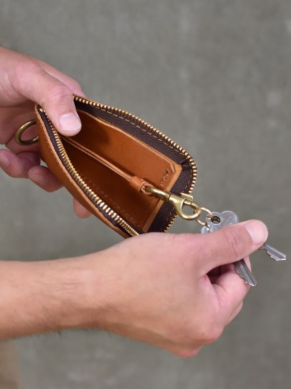 職人手作皮革鑰匙包，淺棕色，拉鍊開合，內有鑰匙掛環，搭配黃銅色五金配件。