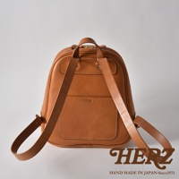 棕色皮革迷你後背包，設有立體前袋和白色縫線，配有可調節的皮革肩帶。