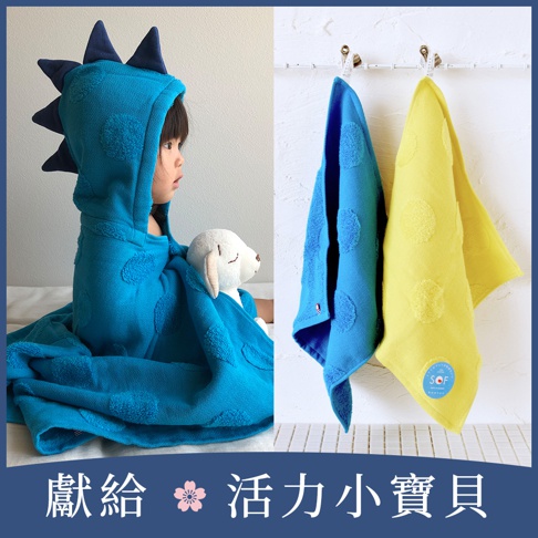 幼兒身穿藍色恐龍造型連帽浴巾，背部設有立體恐龍背鰭，頭部戴上帽子顯得生動可愛，右側展示同款藍色與黃色點點紋路方巾，並懸掛於牆上，下方文字標示獻給活力小寶貝。