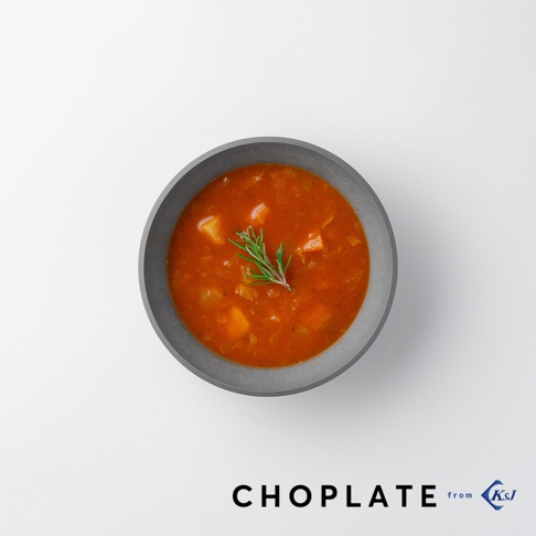 CHOPLATE BOWL沙拉碗，灰色圓形碗中盛有紅色的蔬菜濃湯，湯內有塊狀的蔬菜，碗中央裝飾有迷迭香。