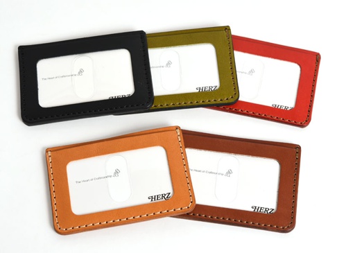 職人手作皮革橫式票券收納夾，展示黑色、橄欖綠、紅色、橘色和棕色共五種顏色，皆為真皮材質，有清晰的縫線細節及透明視窗。