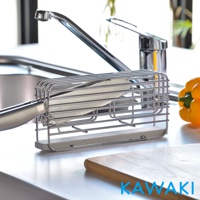 銀色金屬線條構成的珪藻土瀝水刀架，內置一把刀具，底部為淺灰色珪藻土吸水塊，置於廚房水槽旁。