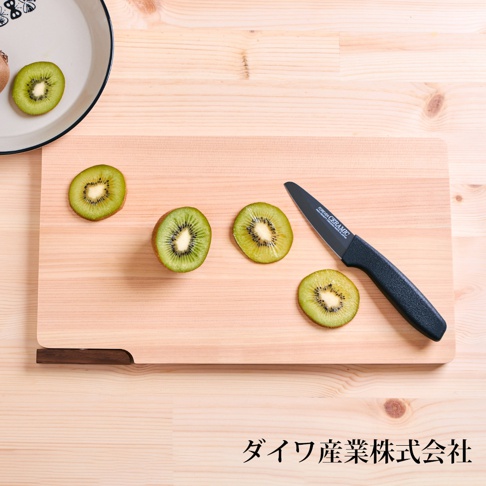日本製超薄檜木砧板，淺木色，有四片奇異果切片和一把黑色陶瓷刀。