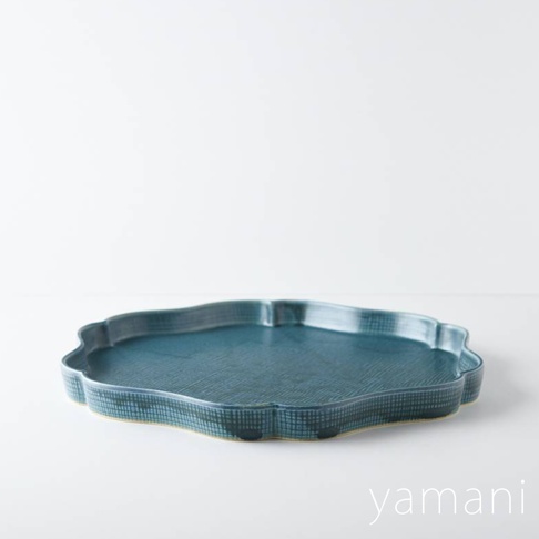 美濃燒花型主食盤，深藍色，表面帶有細緻的格紋紋理，邊緣呈現波浪狀的花瓣造型，質感樸實。