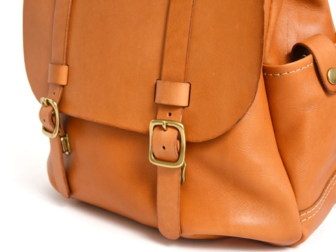 職人手作皮革後背包，經典雙扣設計，皮革色澤自然，帶有金屬扣環與縫線細節。