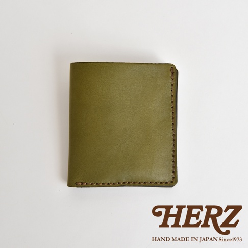 HERZ 職人手作橄欖綠皮革二折式薄型卡片鈔票夾，背面印有 HAND MADE IN JAPAN Since1973。