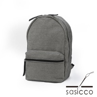 三河木綿刺子織後背包，採用經典的黑白格紋圖案，材質厚實耐磨，主體為圓潤的造型，正面有一個拉鍊口袋，搭配黑色拉鍊與揹帶。