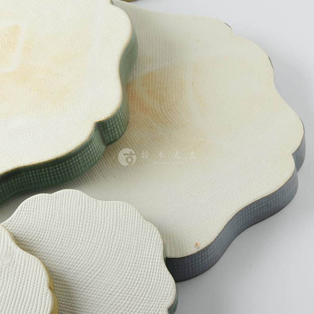 美濃燒花型甜點盤，米白色陶瓷，表面帶有細膩紋理，盤緣為綠色與深灰色。