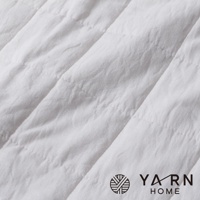 白色脫脂棉混紗速乾格紋毛巾，材質柔軟，紋理清晰，帶有品牌標誌。