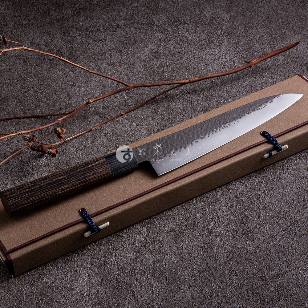 玄 / Chef's knife 主廚刀21cm，黑色木質手柄，鍛造紋理銀色刀身，刀身上有「SUZUKI SHOP」標誌，刀置於棕色禮盒中。
