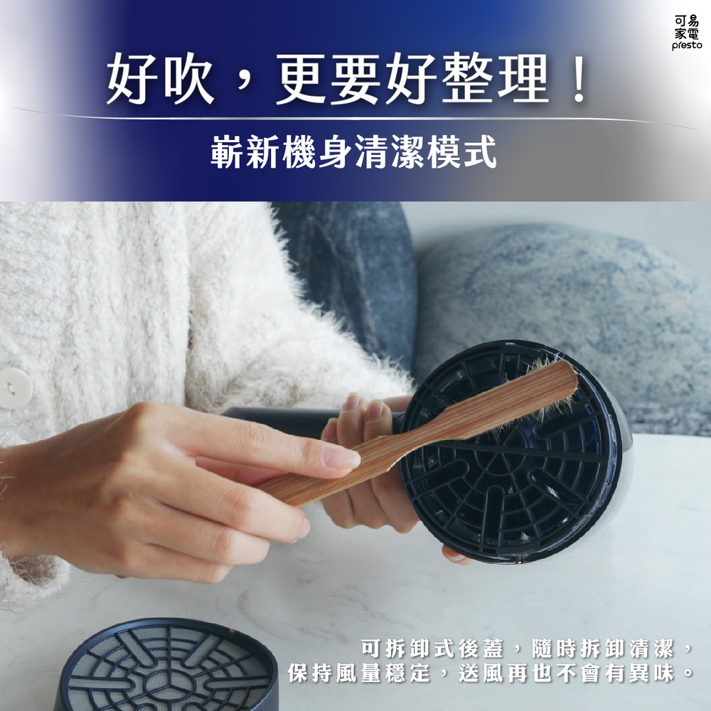 一隻手拿著木質刷子，正在清潔吹風機後部的黑色濾網。