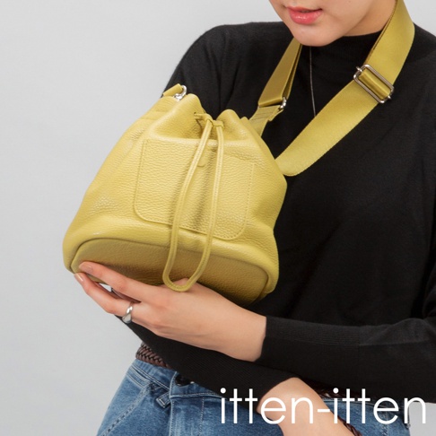itten-itten 品牌標誌下方，一位女性手持一個黃色皮革束口袋包