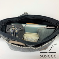 三河木綿刺子織肩背包，外觀為黑白格紋，內部分層收納，可見灰色筆袋、淺色編織錢包、藍色筆記本及手機。