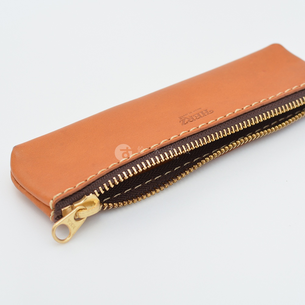 職人手作皮革經典收納筆袋 KP-25，淺棕色皮革，搭配深棕色內裡與金色拉鍊，側邊縫線清晰可見，袋身印有品牌燙金標誌。