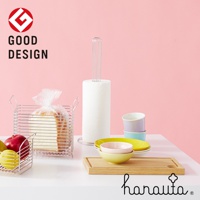 不鏽鋼立式紙巾架，搭配白色紙巾捲，簡潔的銀色金屬支架，置於粉色背景前。